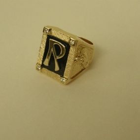 R-kirjaimella koristeltu sormus.